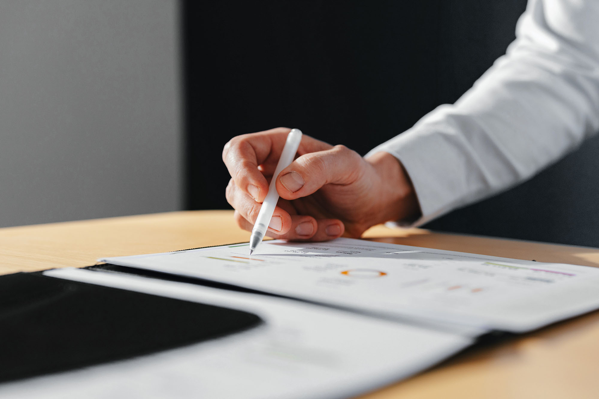 Professional reviewing cybersecurity risk metrics on a printed report, reflecting Drawbridge’s technology-driven approach to monitoring, assessing, and managing security risk for alternative investment firms.