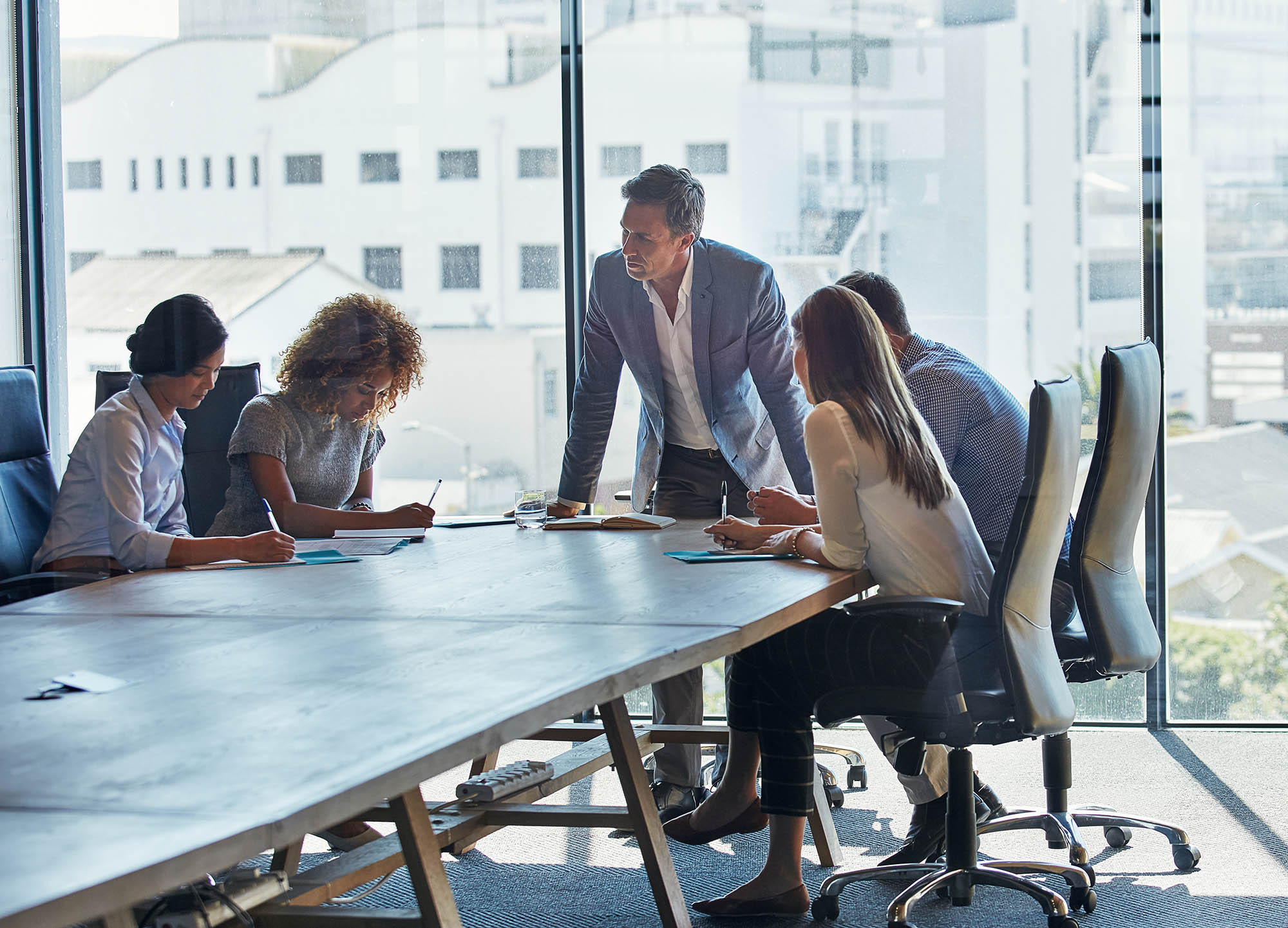 Team meeting in a modern office discussing AI Governance, risk management and compliance.